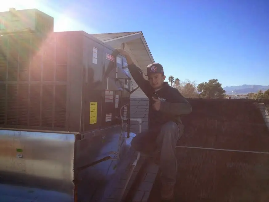 HVAC technician performing Heat Pump Repair on a rooftop unit in Martinez